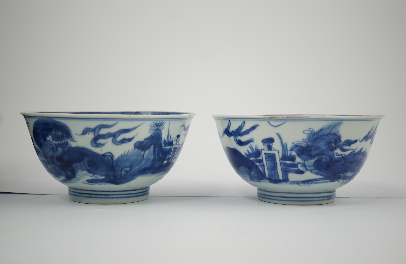 A pair of Chinese Transitional blue and white 'mythical beasts' bowls, early Kangxi period